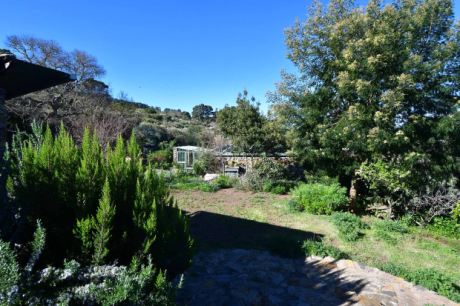 Blick vom Haupthaus auf Gewächshaus und Wassertank